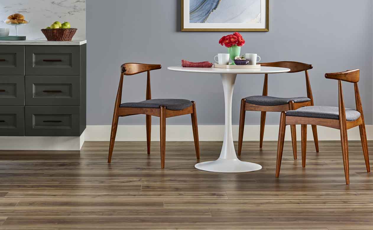 Wood look vinyl flooring in kitchen with white table and gray accent wall